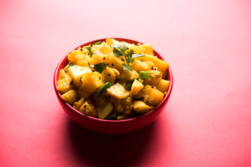 Chatpate Masala Aloo Sabzi fry OR Bombay potatoes served in a bowl, selective focus