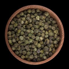 green peppercorn in wooden cup isolated on black. top view
