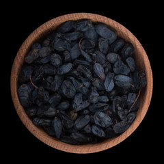 black barberry in wooden cup isolated on black. top view