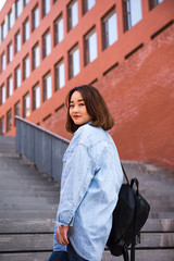 Girl student standing with backpack or school bag smiling happy. Portrait of young Asian female university student 