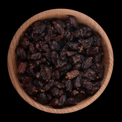 dried red barberry in wooden cup isolated on black. top view