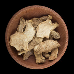 dried ginger in wooden cup isolated on black. top view