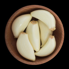 garlic in wooden cup isolated on black. top view