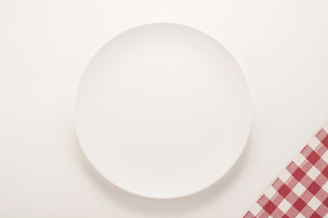  White plate and tablecloth textile on white background 