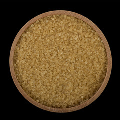 brown sugar in wooden cup isolated on black. top view