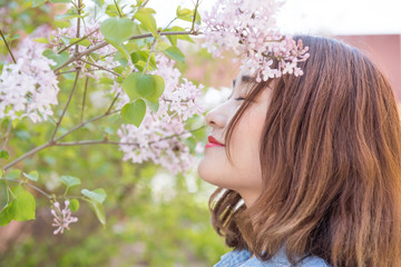 Woman Smelling The Fragrance From A Lilac Tree