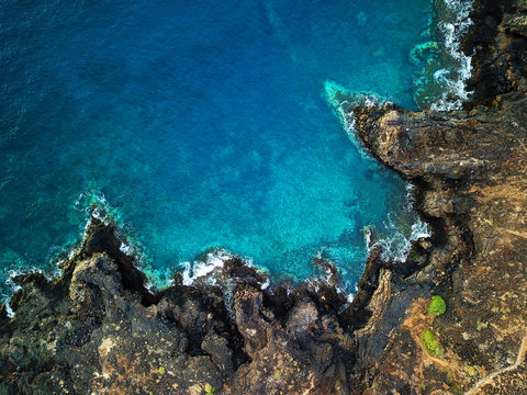 Top view of a deserted coast. Rocky shore of the island of Tenerife. Aerial drone footage of sea waves reaching shore