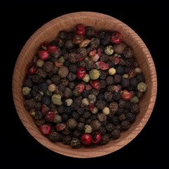 set of peppercorn in wooden cup isolated on black. top view
