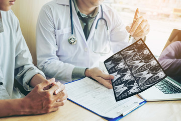 Doctor consulting with patient presenting results on x-ray film About the problem of the patient