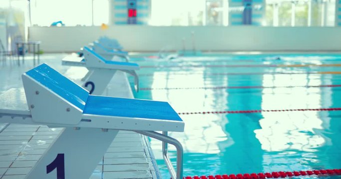 Close-up of an adolescent athlete on the starting block before jumping into the pool
