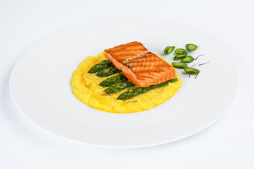 Appetizing salmon dish with risotto, asparagus and saffron.