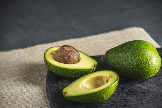 Avocado fruit cut in half on the linen fabric background. Concept organic eco products for food and cosmetic procedures