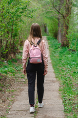 young girl walking along a path in the forest