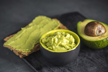 Cold appetizer of mashed avocado flesh with bread on the table. Traditional mexican food from organic eco products