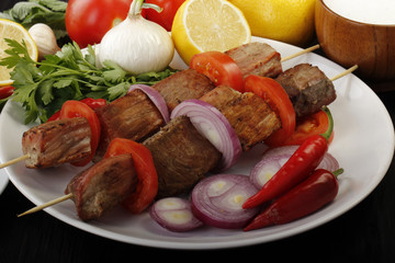 shish kebab with vegetables on wooden background