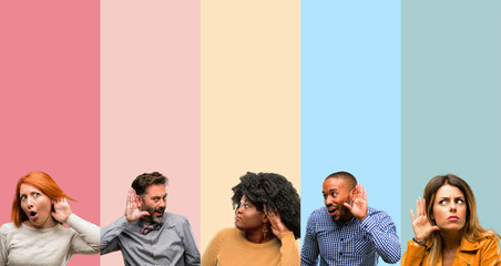 Cool group of people, woman and man holding hand near ear trying to listen to interesting news expressing communication concept and gossip - obrazy, fototapety, plakaty