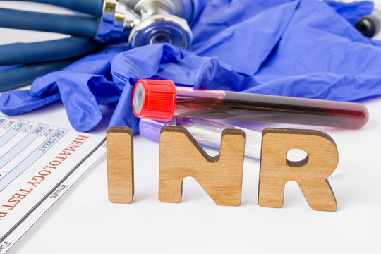 INR Clinical laboratory medical acronym or abbreviation of prothrombin time, blood test for clotting time. Word INR are near laboratory test tubes with blood sample, stethoscope and hematology result