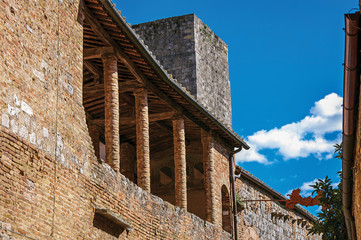 Balcony view on old brick building and tower in San Gimignano. An amazing medieval town famous for having several towers in its historical center. Located in the Tuscany region 