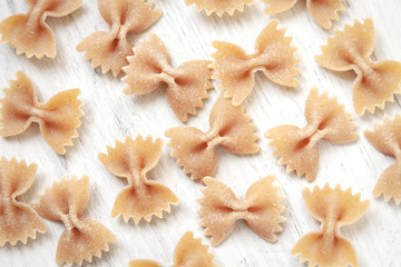 Whole-grained farfals sprinkled on a white wooden table