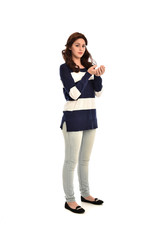  full length portrait of girl wearing striped blue and white jumper and jeans. standing pose on white studio background