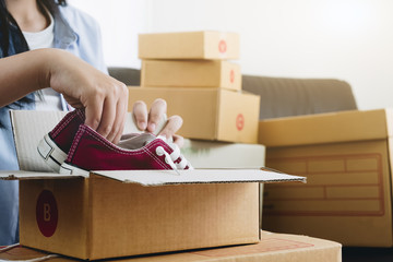 Happy young businessman owner packing shoes to cardboard box, Young Owner Woman Start up for...