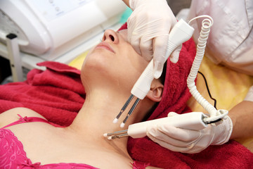 Naklejka premium Microcurrent therapy. Hardware cosmetology. Face rejuvenation. Salon procedure.