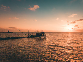 Fototapeta na wymiar Trabucco per pesca nel mare al tramonto