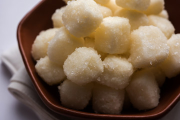 Chena Murki is indian sweet food served in ceramic bowl over moody background. selective focus