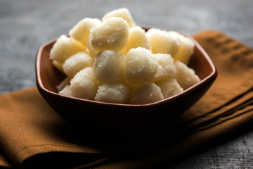Chena Murki is indian sweet food served in ceramic bowl over moody background. selective focus