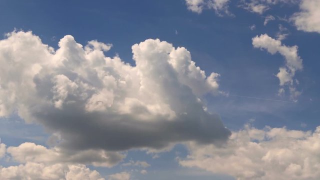 white cumulus clouds float on the blue sky. time-lapse