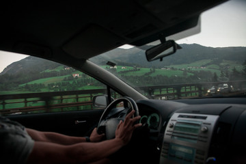the guy behind the wheel.hands on the wheel.mountain view from the car.mountain road