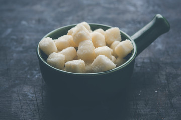 Chena Murki is indian sweet food served in ceramic bowl over moody background. selective focus