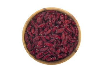 dried red barberry in wooden cup isolated on white background