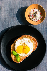 Traditional French sandwich with fried egg on a black plate