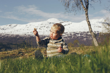 Naklejka na ściany i meble Child playing near the snowy mountains
