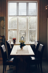Empty table and antique wooden chairs near a window