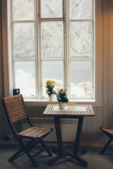 Empty table and antique wooden chairs near a window