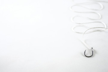 Single hook black fishing hook with white rope on a white backgr