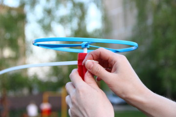 Toy propeller in hand - play with kids on outdoor in summer, launch toy helicopter
