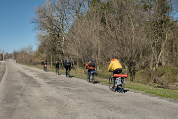 Group of young people riding bicycles on countryside road