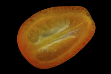 slice of kumquat isolated on black background