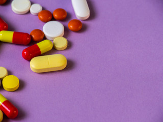 The pills are scattered on the table. Tablets on the lilac background. Medicines.