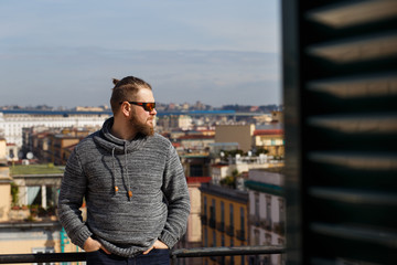 Fototapeta premium Portrait of Young Man with Facial Hair Wearing Eyeglasses in neoclassicism buildings background. Naples. Italy