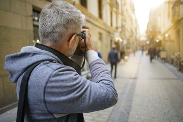 Photographer in European city taking picture of buildings