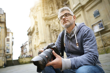 Photographer in European city taking picture of buildings