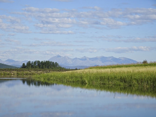 Landscape: calm river and mountains in the background