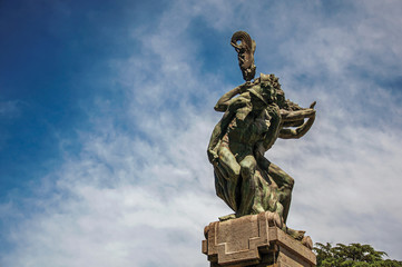 Close-up of bronze sculpture with blue and sunny sky. In a square at the city center of Orvieto, an...