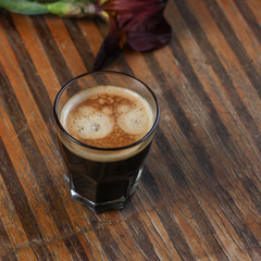 black coffee and foam in a transparent steklnny cup (portion of hot coffee)