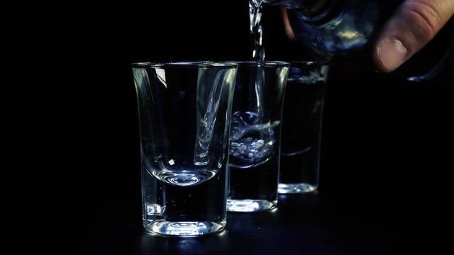 Three shots of vodka are poured into glass