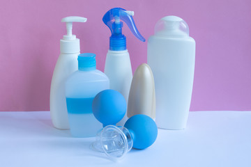Plastic bottles and massage glass jars on pastel modern interior. Hygiene cosmetic concept.